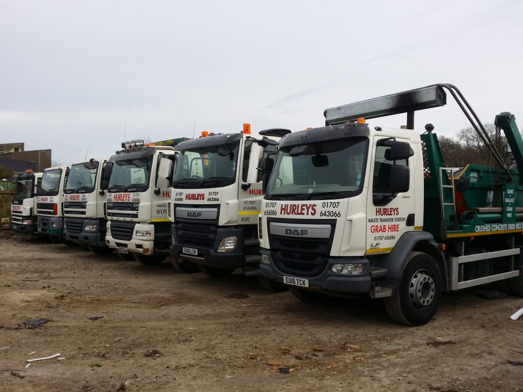 Skip hire trucks lined up at a waste transfer station.