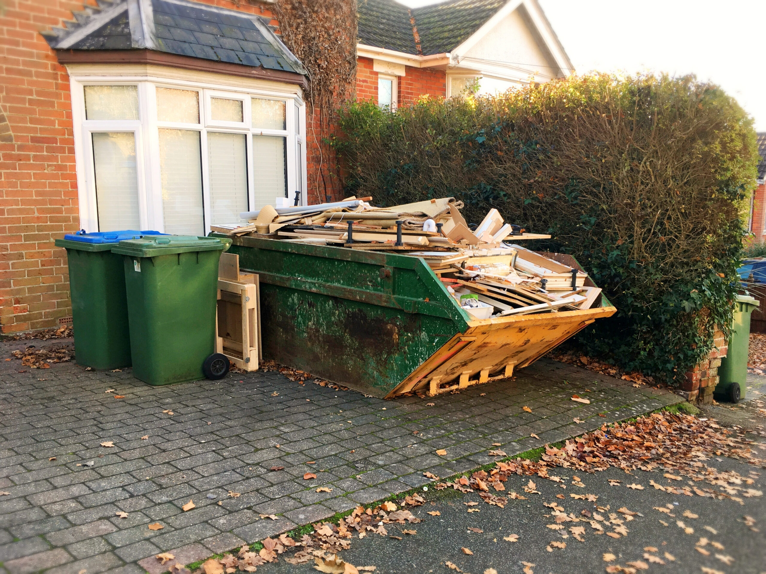 A green and yellow skip located on a private driveway and not requiring a skip permit.